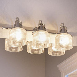Four beautiful UHP2043 Industrial Chic Bath Fixtures, with a polished chrome finish, hanging from the ceiling in a bathroom.