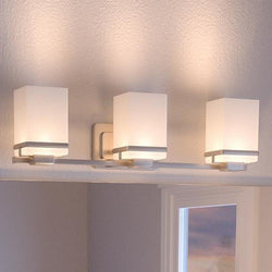 A unique bathroom lighting fixture from Urban Ambiance hangs above the mirror.