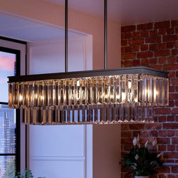 A unique UHP2882 Cosmopolitan Farmhouse Crystal Chandelier, adding luxury to the space, hanging over a brick wall.