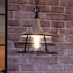 A beautiful lighting fixture, the UHP3850 Urban Loft Pendant Light from the Frederick Collection, hangs in an aged pewter finish from a brick wall.