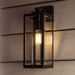 A unique UQL1331 Farmhouse Outdoor Wall Light, 17"H x 6"W, with a beautiful Black Finish from the Quincy Collection by Urban Ambiance on the side of a house.