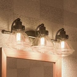 A gorgeous Urban Ambiance Brookline Collection UQL2652 Transitional Bathroom Vanity Light, 8"H x 25"W, Bronze Finish with three lights and a mirror.
