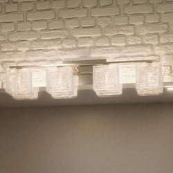 A beautiful bathroom with a unique Urban Ambiance UQL2724 Modern Bathroom Light, 6.75"H x 32"W, Brushed Nickel Finish, San Diego Collection above a brick wall.