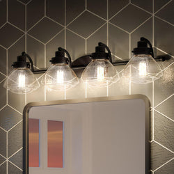 An Urban Ambiance bathroom vanity with four beautiful Colonial Bath Vanity Lights, 8"H x 33.75"W, Parisian Bronze Finish, from the Brookline Collection and a mirror.