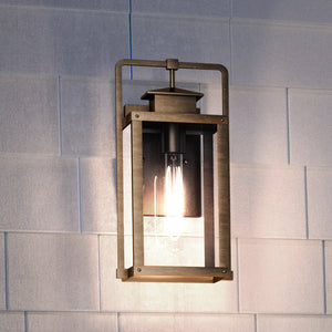 A beautiful Lux Industrial Outdoor Wall Sconce 14''H x 7''W, Antique Brass Finish, from the Knoxville Collection, on a brick wall.