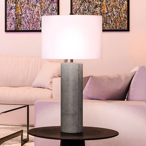 A gorgeous UEX7120 Modern Table Lamp with a polished concrete finish and white shade, offering luxury lighting in a living room.