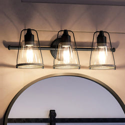 A beautiful Coastal Bath Light with a unique Midnight Black Finish, part of the luxurious Kempsey Collection, featuring three lights and a mirror.