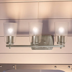 An Urban Ambiance bathroom vanity with three UHP4142 Traditional Bath Lights in a beautiful Brushed Nickel Finish from the Esperance Collection and a mirror.