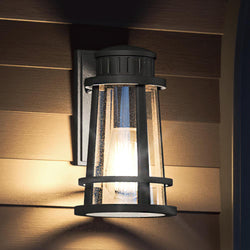 A gorgeous UQL1582 Tudor lamp, featuring a beautiful Natural Black Finish, from the Westcliffe Collection by Urban Ambiance on a wooden wall.