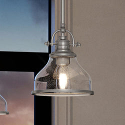 An Urban Ambiance unique lighting fixture with a glass shade hanging over a window.