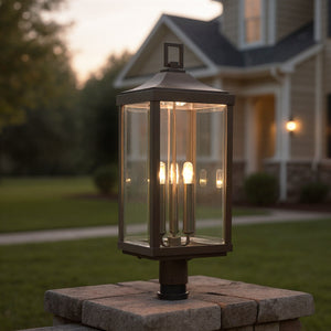 The Urban Ambiance UHP1190 Colonial Outdoor Post/Pier Light from the Calderdale Collection, featuring an Olde Bronze finish, is mounted on a stone pillar and enhances any home's entryway with timeless outdoor charm.