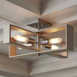 The UHP4916 Minimalist Indoor Ceiling Light from Urban Ambiance’s Roswell Collection features a contemporary geometric design with exposed bulbs, brushed nickel accents, and a rectangular wooden frame. Measuring 9-1/4′‘ high and 24″ wide by 24’’ deep, this striking ceiling fixture is mounted on a white-paneled ceiling, blending modern style with the warmth of natural materials.