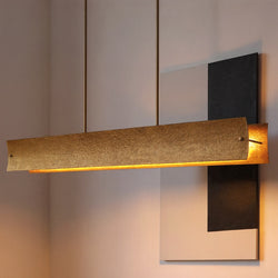 The UHP5032 Modern Rustic Indoor Chandelier by Urban Ambiance, with a soft gold finish, hangs elegantly in front of minimalist black-and-white wall art, giving the space a stylish modern rustic look.