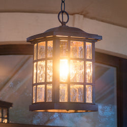 The Urban Ambiance UQL1250 Craftsman Outdoor Pendant Light, 15"H x 9.5"W in Black Silk from the Zurich Collection, features a metal frame and glass panels—perfect for casting a warm glow on your patio.
