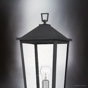 A close-up of the Urban Ambiance UQL1874 Modern Rustic Outdoor Post Light from the Elmwood Collection, featuring seeded glass panels, a visible bulb, and a mottled black marine-grade finish.
