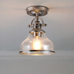 The UQL3663 Traditional Ceiling Light by Urban Ambiance features a brushed nickel finish and clear glass shade, adding sleek industrial style to any space. Part of the Pasadena Collection, it measures 10.5''H x 8''W.