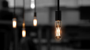 Four Urban Ambiance UBB2132 Luxury LED bulbs (40W equivalent, vintage Edison T6, E12 base, 2700K warm white) glow against a dark blurred background, with the foreground bulb in sharp focus. Sold as a 4-pack.
