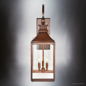 The Urban Ambiance UFS1002 Transitional Outdoor Wall Sconce from the Calderdale Collection features genuine copper in a dark-patina finish with two visible bulbs and beveled glass, shown against a neutral gray background.