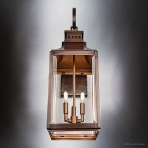 The Urban Ambiance UFS1002 Calderdale Collection Outdoor Wall Sconce features a transitional Colonial-inspired design in genuine copper with dark-patina finish, beveled glass, and two candle-style bulbs. Size: 28.5