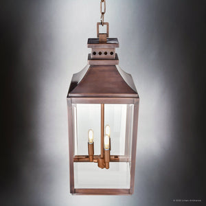 The Urban Ambiance UFS1004 Calderdale Collection Transitional Outdoor Pendant Light features a genuine copper, dark-patina finish with glass enclosure and three visible bulbs, measuring 26.5''H x 9.5''W, suspended by a chain.