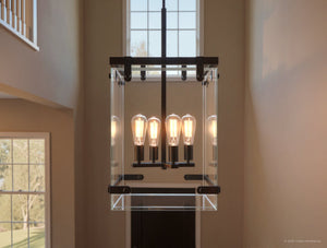 The UHP2442 Modern Farmhouse Modern Chandelier by Urban Ambiance from the Bristol Collection, featuring a striking Olde Bronze finish and six exposed bulbs, hangs elegantly in a tall foyer with large windows and beige walls, lending a modern farmhouse touch to the space.