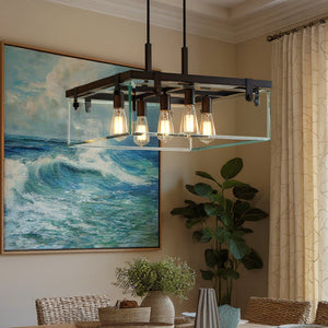 The UHP2444 Modern Farmhouse Square Chandelier from the Bristol Collection by Urban Ambiance, featuring an Olde Bronze finish and exposed bulbs, hangs above the dining table. A large ocean painting, a potted plant, and beige curtains complete the room’s decor.