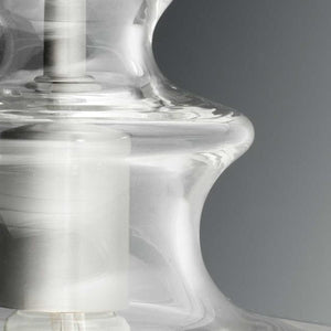 Close-up of the Urban Ambiance UHP3043 Modern Farmhouse Pendant Light from the Dundee Collection, featuring a transparent hand-blown glass shade and a metallic inner rod in a brushed nickel finish, set against a plain gray background.
