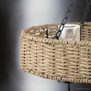 Featuring a close-up of the UHP4781 Casual Indoor Chandelier from the Urban Ambiance Bexley Collection, this matte black fixture boasts a woven basket-style design with a candle inside. It's suspended by chains against a gray background, making it perfect for outdoor settings due to its weather-resistant rattan construction that adds both charm and durability to your space.