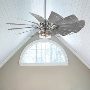 The Urban Ambiance UHP9477 Tuscan Indoor Ceiling Fan in Antique Nickel graces a room with a vaulted ceiling and arched window, adding sophistication with its modern industrial design and light kit.
