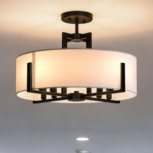 The Urban Ambiance UKC20373 Transitional Indoor Ceiling Light from the Oakmont Collection features a drum-shaped fabric shade and a sleek black metal frame, mounted on a white ceiling. Measuring 14.5'' high and 20'' wide, this ceiling light blends seamlessly with both contemporary and classic interiors.