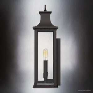 The Urban Ambiance UQL1720 Classic Outdoor Wall Sconce from the Halle Collection features marine-grade construction, an old bronze finish, clear glass enclosure, and a single exposed bulb. Size: 19.50''H x 8.25''W x 6.50''D.