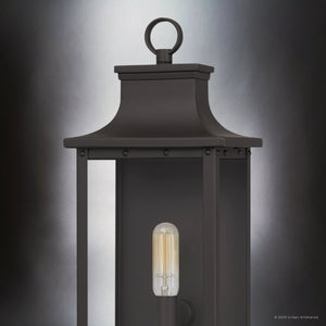 Close-up of the Urban Ambiance UQL1721 Classic Outdoor Wall Sconce from the Halle Collection, featuring old bronze finish, marine-grade construction, and beveled glass panels with a visible filament bulb. Size: 15.50''H x 6.50''W x 5.50''D.