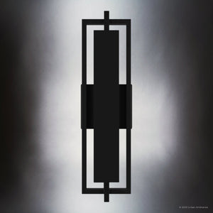 The UQL1840 Modern Outdoor Wall Sconce by Urban Ambiance features a geometric matte black frame, marine-grade construction, and integrated LED, shown mounted vertically against a softly lit gray background. 20.50''H x 5.75''W x 3.75''D, Juniper Collection.