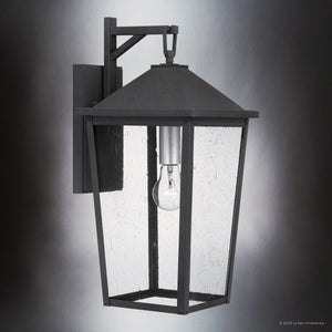 The Urban Ambiance UQL1871 Modern Rustic Outdoor Wall Sconce from the Elmwood Collection features a mottled black marine-grade finish, visible bulb, and clear glass panels. Dimensions: 19.75''H x 9.25''W x 11.00''D.