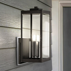 The Urban Ambiance UQL1892 Quincy Collection outdoor wall sconce features a modern farmhouse design with natural black finish and beveled glass, measuring 22.75''H x 9.00''W, stylishly mounted on gray siding by the door.