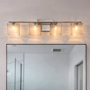 The Urban Ambiance UQL2724 Modern Bathroom Light from the San Diego Collection, featuring a brushed nickel finish and wavy glass light shades, is mounted above a rectangular bathroom mirror in a modern-setting; it measures 6.75 inches high by 32 inches wide.