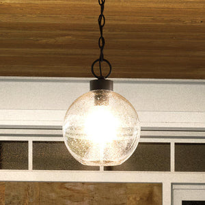 An UQL1510 Contemporary Outdoor Pendant Light, 13.75"H x 10.25"W, Ash Black Finish, Clifton Collection beautiful lighting fixture hanging over a wooden deck by Urban Amb