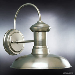 The Urban Ambiance Palermo Collection UHP1025 Luxe Industrial Chic Outdoor Wall Light features a brushed metal construction with an aged nickel finish, a gracefully curved arm, and a wide dome-shaped shade, all in an eye-catching industrial design set against a gray gradient background. This fixture measures 10.75″ high by 10″ wide.