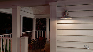 An Urban Ambiance UHP1030 Industrial Chic Outdoor Wall Light from the Palermo Collection, placed on a porch with a table and chairs.