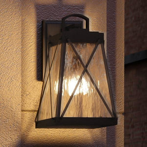 The Urban Ambiance UHP1053 English Country Outdoor Wall Light from the Saint Paul Collection features a midnight black metal frame and textured glass, beautifully illuminating your exterior wall with classic English-inspired charm—perfect for enhancing any outdoor space. Measures 15-3/4″ high by 8-3/8″ wide.