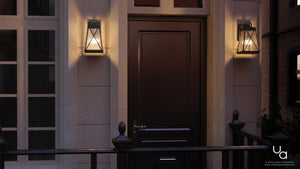 A dark brown front door with two Urban Ambiance UHP1053 English Country Outdoor Wall Lights from the Saint Paul Collection, featuring a midnight black finish and rustic lantern design, mounted on either side against a light-colored exterior with windows and a black railing.