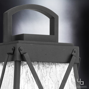 Close-up of the UHP1057 English Country Outdoor Post/Pier Light from Urban Ambiance’s Saint Paul Collection, showcasing its textured glass panels and midnight black metal frame, inspired by vintage lantern design, set against a gradient gray background.