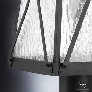 Close-up of the UHP1057 English Country Outdoor Post/Pier Light from Urban Ambiance’s Saint Paul Collection, featuring textured glass panels and a midnight black metal frame with angled design accents and visible corner screws—blending vintage lantern charm with contemporary style in a 21-3/4″ high by 10-1/2″ wide silhouette.