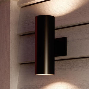 A gorgeous outdoor wall lamp from the Hollywood Collection, with an Olde Bronze finish, mounted on the side of a house.