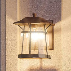A beautiful UHP1071 Rustic Outdoor Wall Light on the side of a building.