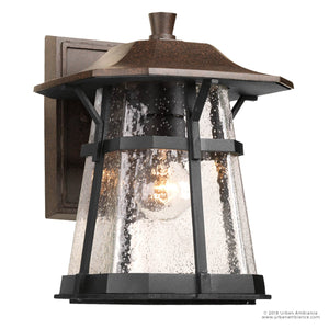 The Urban Ambiance UHP1071 Rustic Outdoor Wall Light from the Gold Coast Collection features a coffee bronze finish, a clear seeded glass shade, and a rectangular backplate with visible bulb illumination—an ideal choice for bringing rustic coastal charm to your exterior spaces.