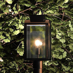 A unique black outdoor post light with a luxurious oil rubbed bronze finish, featuring the UHP1103 Art Deco Chesterfield Collection light bulb.