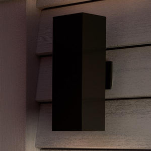 A unique UHP1111 lamp, part of the luxury Madrid Collection by Urban Ambiance, adorns the side of a house with its minimalist design and Olde Bronze finish.