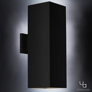 The UHP1112 Minimalist Outdoor Wall Light from Urban Ambiance’s Madrid Collection features a sleek, rectangular design in a midnight black finish, measuring 18 inches high by 6 inches wide. Crafted from die-cast aluminum, it emits light from both the top and bottom edges and is shown mounted on a gray background—an ideal minimalist choice for any contemporary outdoor wall sconce application.