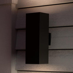 An UHP1112 Minimalist Outdoor Wall Light, 18"H x 6"W, Midnight Black Finish from the Madrid Collection by Urban Ambiance providing luxury lighting on the side of a house.